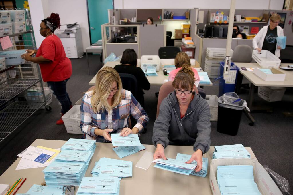 Sonoma County election workers Lora Botteri and Jody Brady sort mail-in ballots at Registrar of Voters Office on Nov. 7. (BETH SCHLANKER / The Press Democrat)
