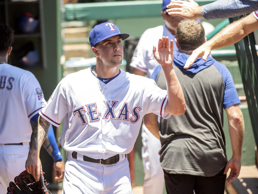 Texas Rangers starting pitcher Joe Palumbo, making his major league debut, is congratulated in the dugout after throwing in the first inning against the Oakland Athletics in the first game of a doubleheader Saturday, June 8, 2019, in Arlington, Texas. Texas won 10-5. (AP Photo/Jeffrey McWhorter)