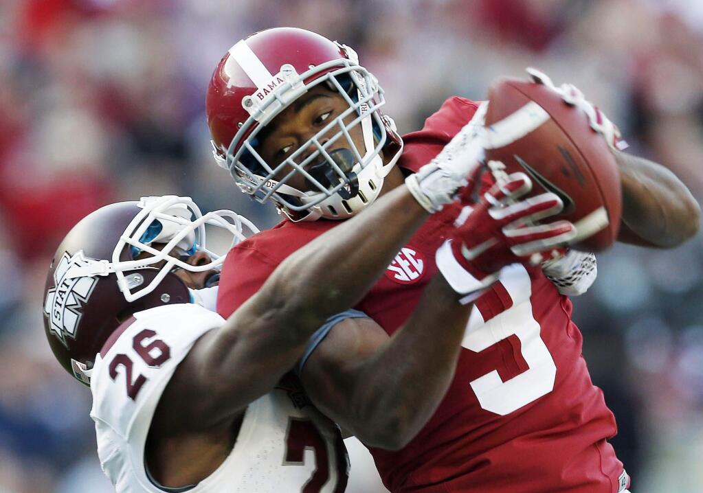 In this Nov. 15, 2014, file photo, Alabama wide receiver Amari Cooper (9) catches a 50-yard pass against Mississippi State defensive back Kendrick Market (26) in the first half of an college football game in Tuscaloosa, Ala. (AP Photo/Butch Dill, File)