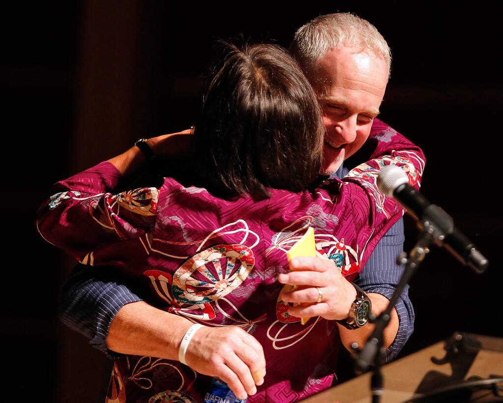 Santa Rosa firefighter Tony Niel embraces Sonoma State University president Judy Sakaki after they shared their stories from the night of the Tubbs Fire during Thicker Than Smoke, an evening of community storytelling at Sonoma State University's Weill Hall in Rohnert Park, California, on Friday, August 3, 2018. (Alvin Jornada / The Press Democrat)