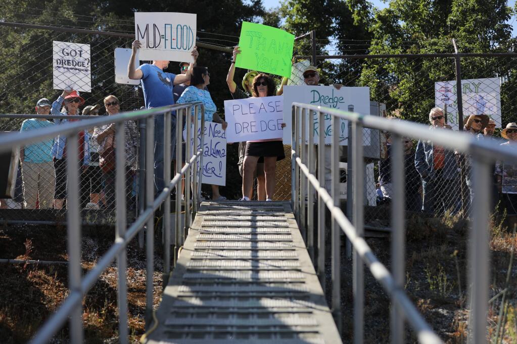 People hold signs supporting the dredging the Petaluma River at an event hosted by Petaluma Mayor Teresa Barrett for Rep. Jared Huffman and US Army Corps of Engineers Lt. Col. John D. Cunningham to tour the Petaluma River in Petaluma, California on Friday, August 2, 2019. (BETH SCHLANKER/The Press Democrat)