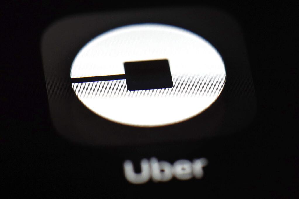 FILE - This March 20, 2018, file photo shows the Uber app on an iPad in Baltimore. U.S. employment regulators are investigating allegations that Uber set up a pay scale that discriminated against women working for the ride-hailing service. (AP Photo/Patrick Semansky, File)