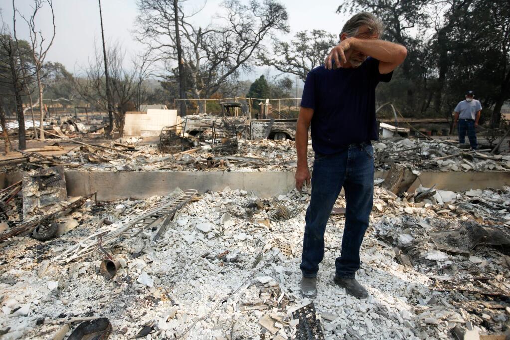 The Nuns fire destroyed approximately 54 thousand acres: 34,398 in Sonoma County and 20,025 in Napa County. Jack O'Callaghan wipes sweat off his forehead while he sifts through the ashes of his home, in Glen Ellen, California on Tuesday, Oct. 10, 2017. O'Callaghan's home was destroyed as the Nuns fire swept through the area early Monday morning. (ALVIN JORNADA/PD)