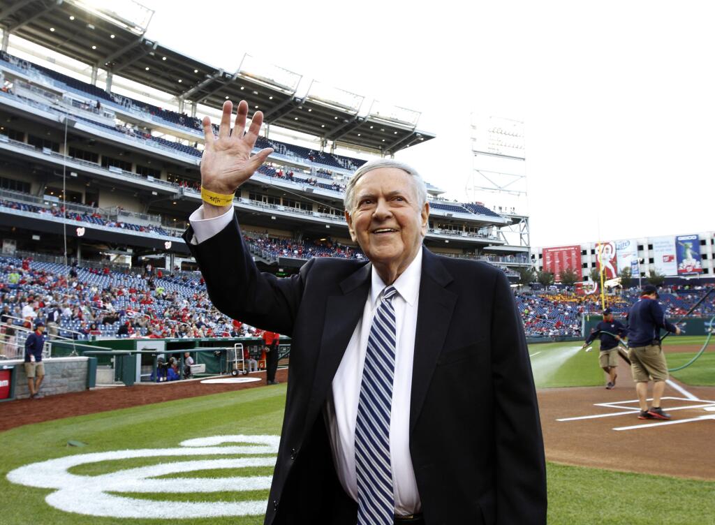 FILE - In this Friday, April 26, 2013 file photo, former Washington Senators broadcaster Bob Wolff waves to the crowd during a pre-game ceremony to honor him, before a baseball game between the Washington Nationals and the Cincinnati Reds at Nationals Park in Washington. Bob Wolff, the only sportscaster to call play-by-play of championships in all four major North American professional team sports, has died, Saturday, July 15, 2017. He was 96. (AP Photo/Alex Brandon, File)
