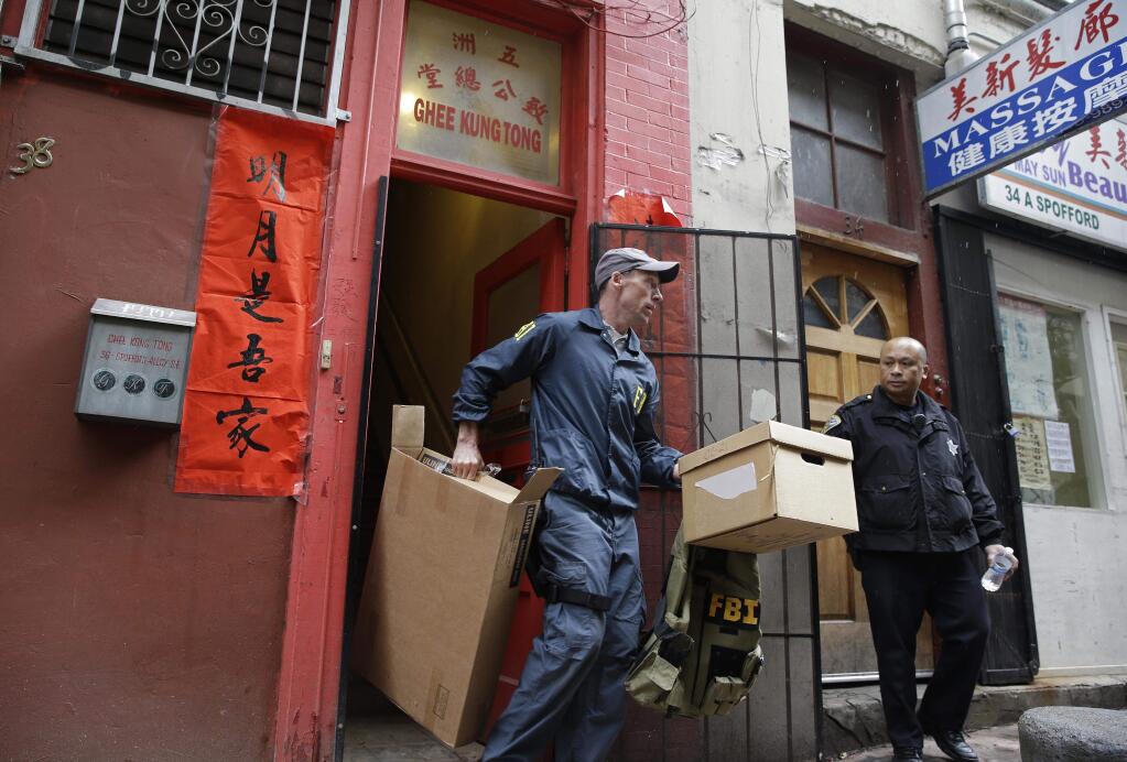 FILE - In this March 26, 2014 file photo, an FBI agent carries out boxes of evidence following a search of a Chinatown fraternal organization in San Francisco. Raymond Chow, a one-time gang tough nicknamed 'Shrimp Boy' who insisted he had changed his ways but was hounded by federal investigators is set to be sentenced to life in prison following his conviction on racketeering, murder and scores of other charges. U.S. District Court Judge Charles Breyer is scheduled to sentence Chow on Thursday, Aug. 4, 2016. (AP Photo/Eric Risberg, File)
