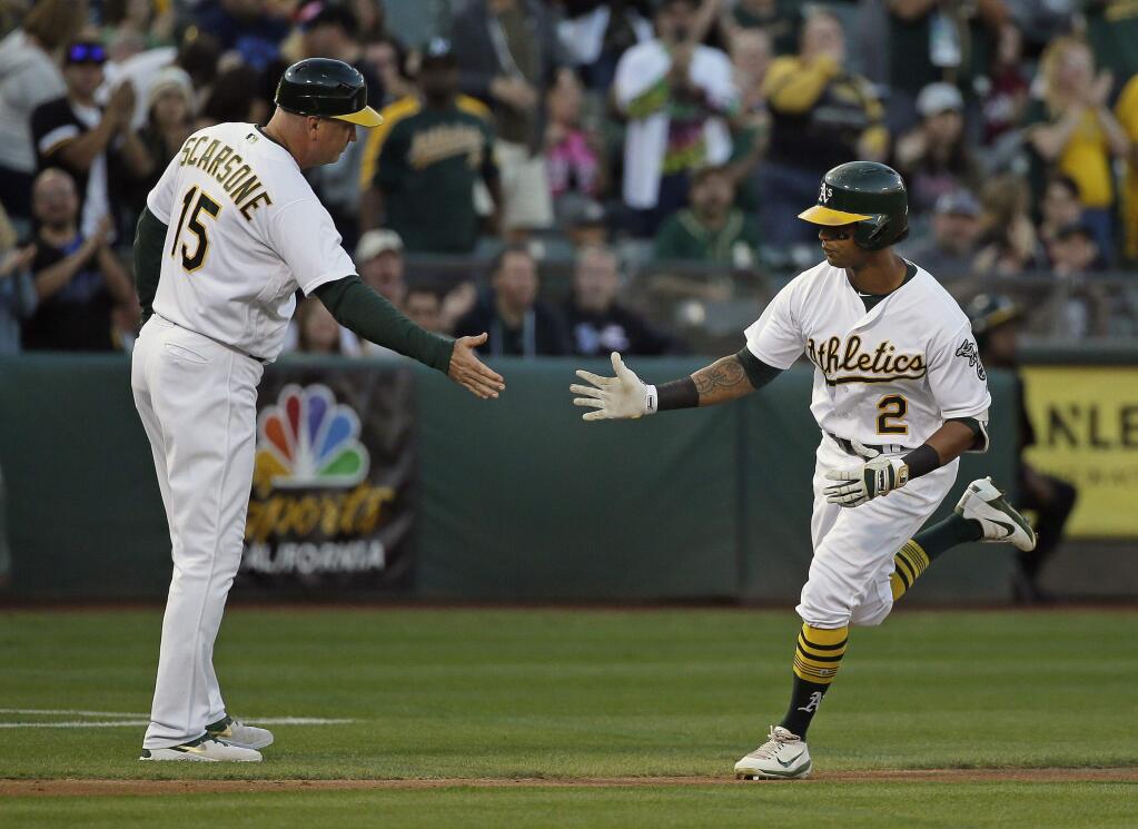 Oakland Athletics' Khris Davis, right, is greeted by third base coach Steve Scarsone, left, after hitting a home run off Texas Rangers starting pitcher Miguel Gonzalez in the second inning of a baseball game Saturday, Sept. 23, 2017, in Oakland, Calif. (AP Photo/Eric Risberg)