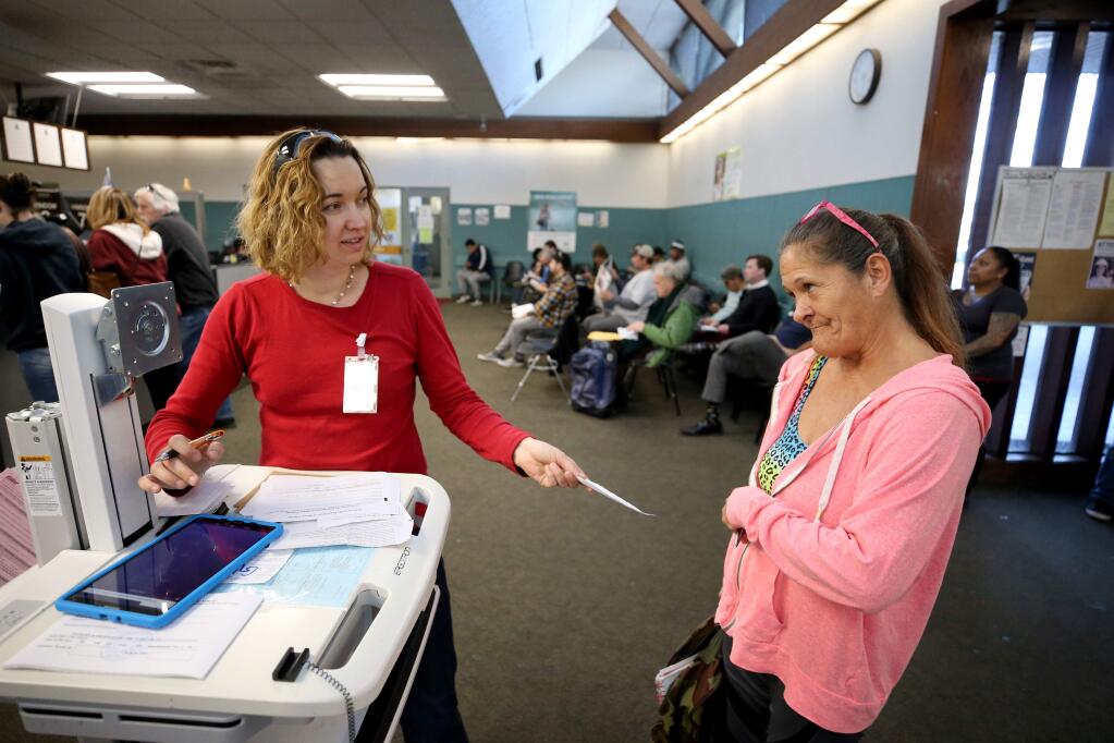 Motor vehicle representative Anya Hawkins, left, helps Nancy Reynaga figure out where to go to get a new ID at the Department of Motor Vehicles in Santa Rosa on Tuesday, January 7, 2020. (BETH SCHLANKER/ The Press Democrat)