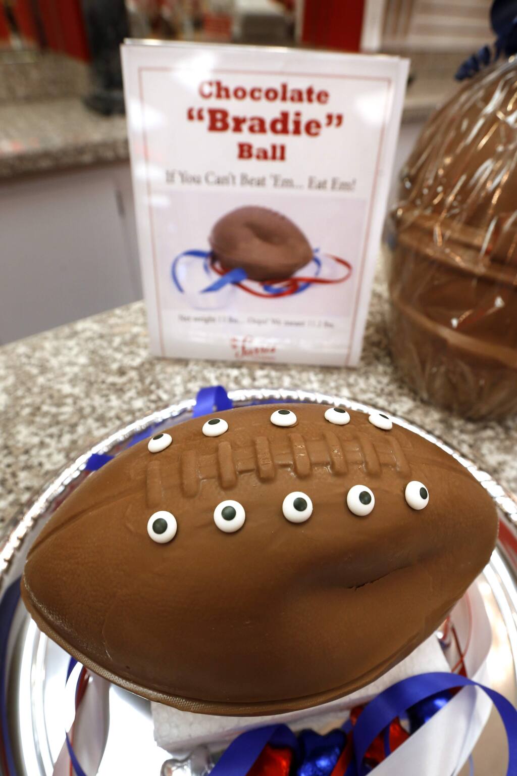 A 'deflated' chocolate football called a 'Bradie' Ball is on display at Sarris Candy store in in Canonsburg, Pa., on Wednesday, Jan. 28, 2015. Owner Bill Sarris says they came up with the idea to poke fun at the controversy surrounding under-inflated footballs on Tuesday. The display item isn't for sale. (AP Photo/Keith Srakocic)
