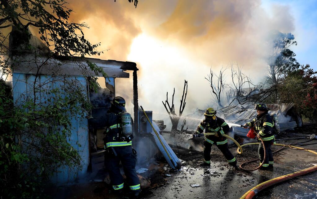 Firefighters with Forestville and the Sonoma County Fire District squelch a home fire in Windsor, Thursday, Aug 1, 2019. (Kent Porter / The Press Democrat) 2019