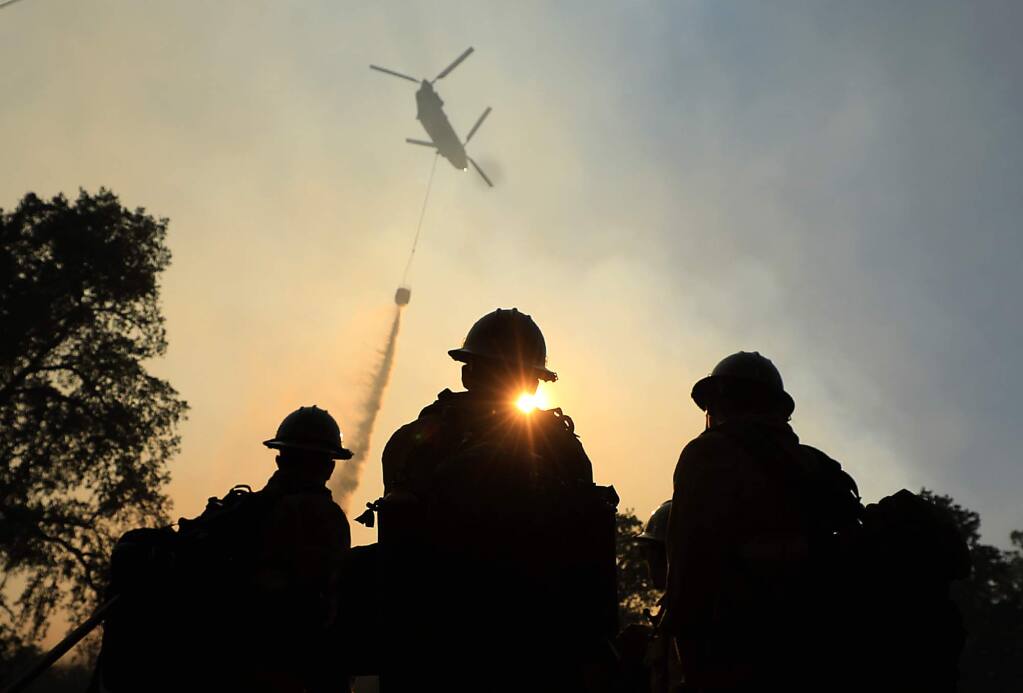 Ventura County firefighters watch as a helicopter makes a drop on a hot spot of the River fire in Scotts Valley near Lakeport, Friday, August 3, 2018. (Kent Porter / The Press Democrat) 2018