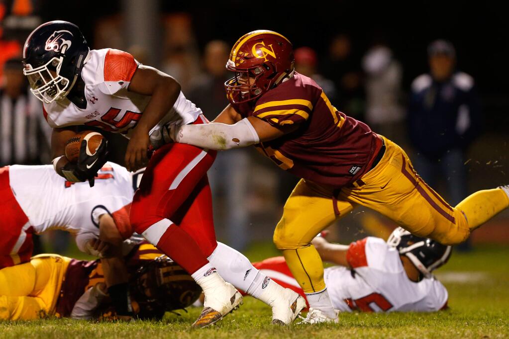 Rancho Cotate running back Rasheed Rankin, left, gets tackled by Cardinal Newman middle linebacker Dino Kahaulelio during the first half of a varsity football game between Rancho Cotate and Cardinal Newman high school in Santa Rosa on Friday, September 28, 2018. (Alvin Jornada / The Press Democrat)