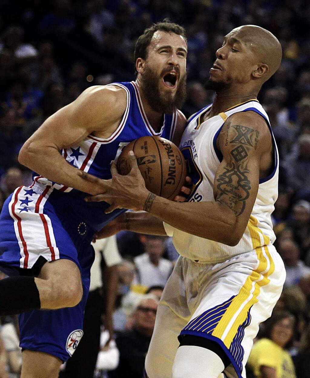 Philadelphia 76ers' Sergio Rodriguez, left, and Golden State Warriors' David West fight for the ball during the first half of an NBA basketball game Tuesday, March 14, 2017, in Oakland, Calif. (AP Photo/Ben Margot)