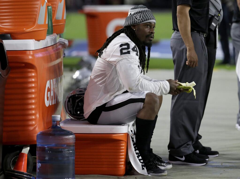 Oakland Raiders running back Marshawn Lynch sits during the national anthem prior to the team's preseason game against the Arizona Cardinals, Saturday, Aug. 12, 2017, in Glendale, Ariz. (AP Photo/Rick Scuteri)