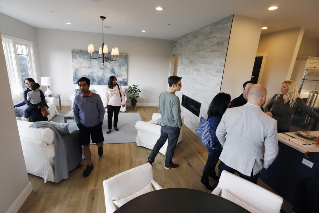 People mill about the family room during the open house of a spec home at 3797 Rocky Knoll Way on the market for $1.795 million by Berkshire Hathaway HomeServices in Santa Rosa, California on Sunday, February 10, 2019 . (BETH SCHLANKER/The Press Democrat)
