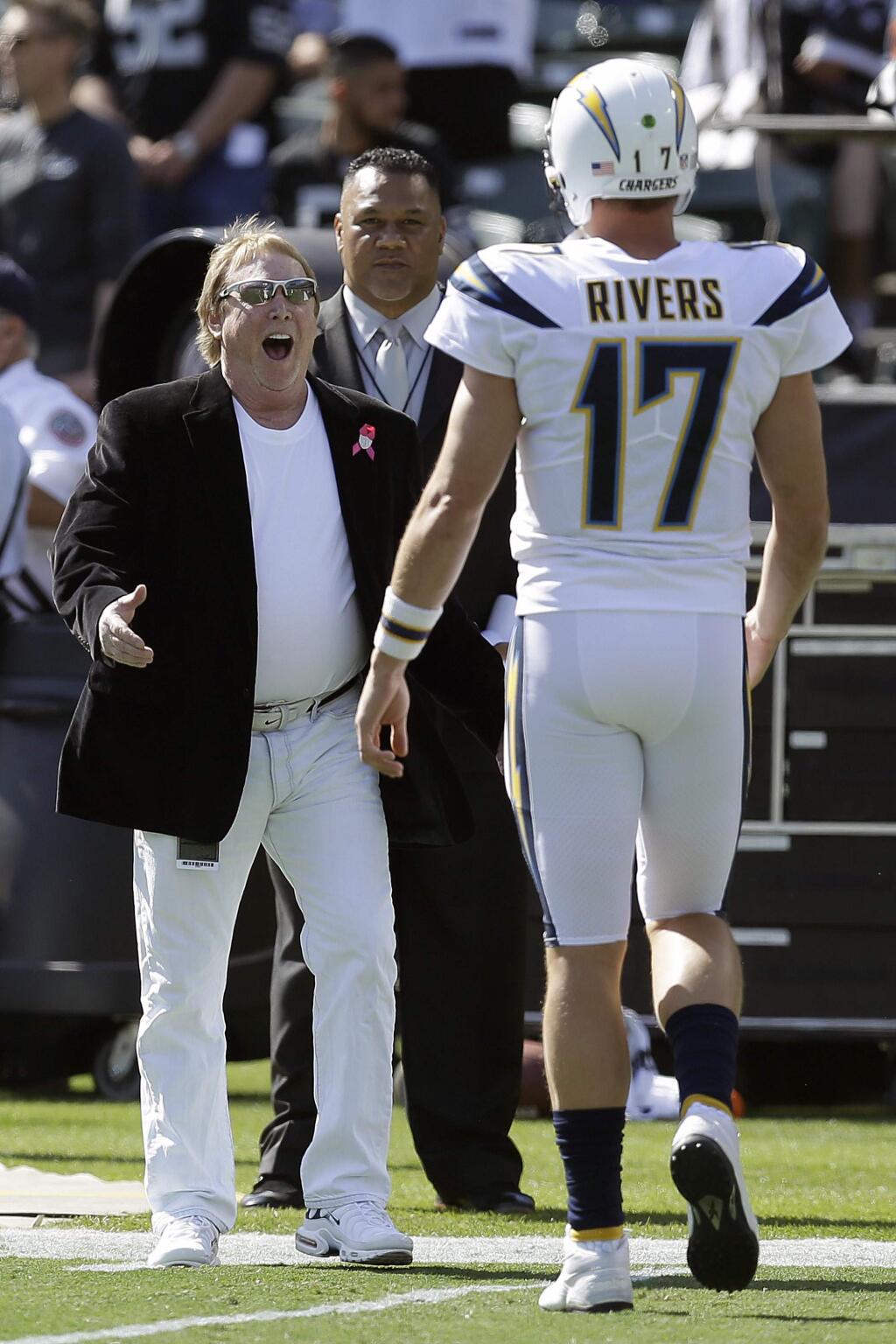 FILE - In this Oct. 15, 2017, file photo, Oakland Raiders owner Mark Davis, left, greets Los Angeles Chargers quarterback Philip Rivers (17) before an NFL football game between the Raiders and the Chargers in Oakland, Calif. From his first career start in 2006 to some riveting comebacks and crushing defeats, Chargers quarterback Philip Rivers has had plenty of memorable experiences playing against the Raiders at the Oakland Coliseum.So there will be a bit of nostalgia when Rivers plays his final scheduled game there Thursday night, Nov. 17, 2019, when the Chargers (4-5) take on the Raiders (4-4) in a game crucial for both teams' playoff hopes. (AP Photo/Ben Margot, File)