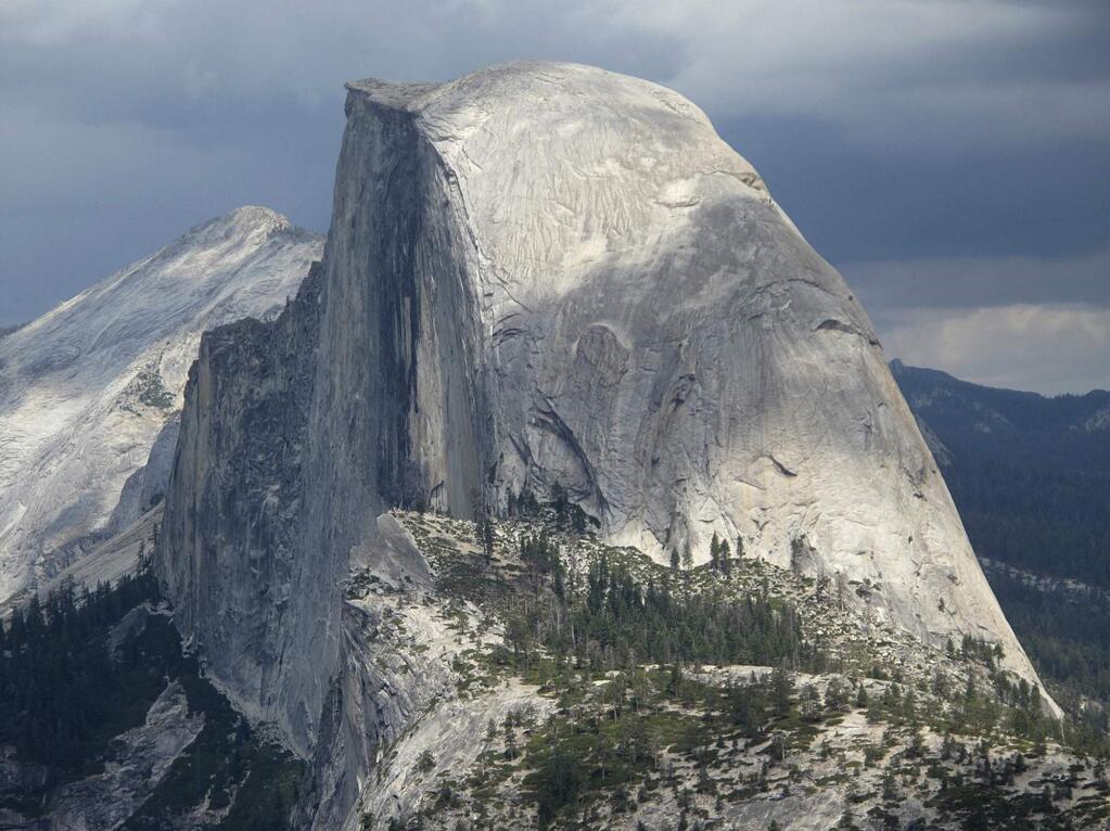 FILE - This August 2011 file photo shows Half Dome and Yosemite Valley in a view from Glacier Point at Yosemite National Park, Calif. A hiker in Yosemite National Park fell to his death while climbing the iconic granite cliffs of Half Dome in rainy conditions. The National Park Service said the accident occurred Monday, May 21, 2018. NPS spokeswoman Jamie Richards said the man and a companion were scaling the steepest part of the trail where rangers recently installed cables to help hikers get to the top of the 8,800-foot rock face. (AP Photo/Tracie Cone, File)