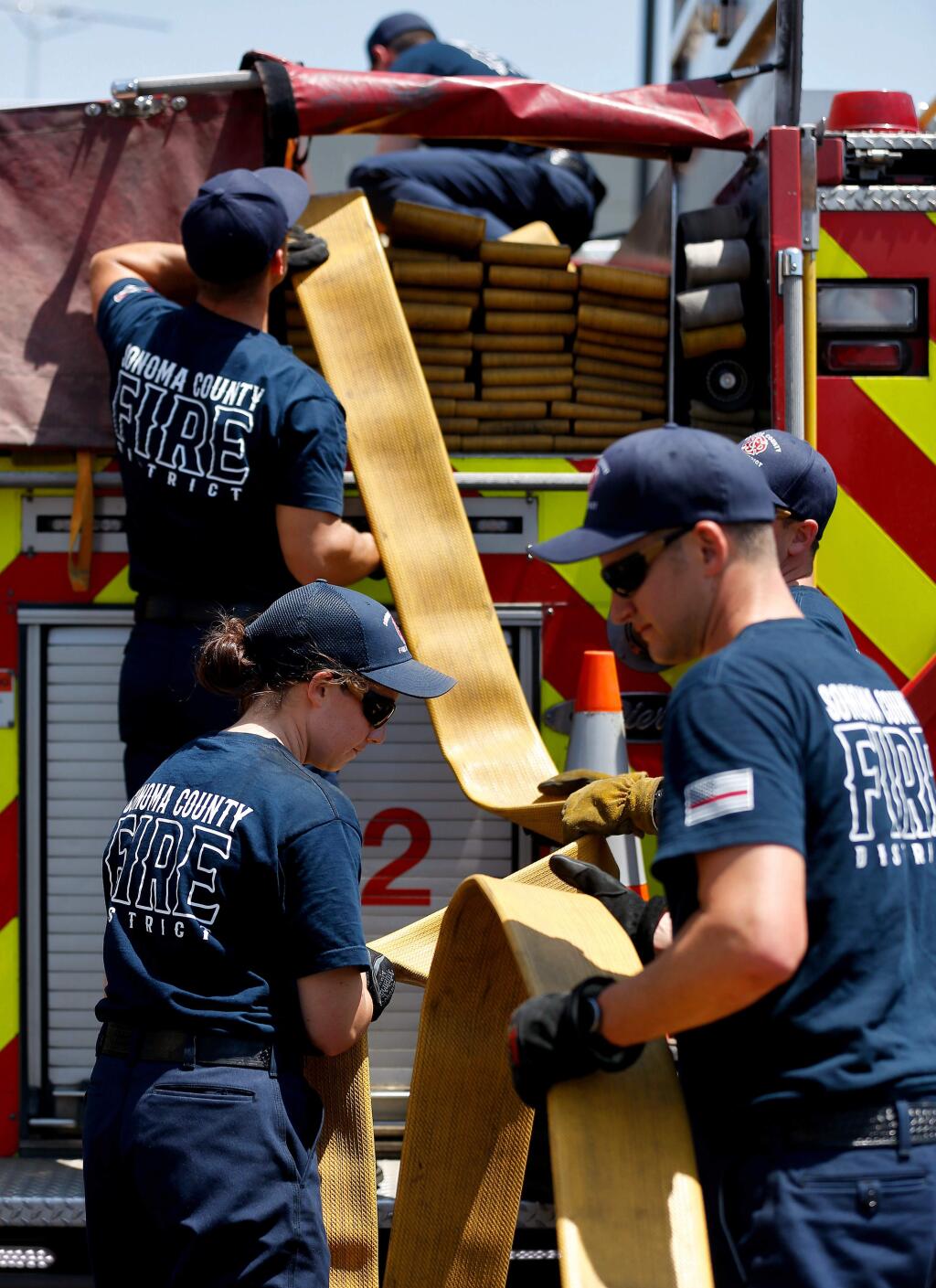 Recruit firefighters of Class 19-1 reload supply hose onto a fire engine between training evolutions during the Sonoma County Fire District Firefighter Recruit Academy at Santa Rosa Junior College Public Safety Center in Santa Rosa, California, on Wednesday, May 29, 2019. (Alvin Jornada / The Press Democrat)