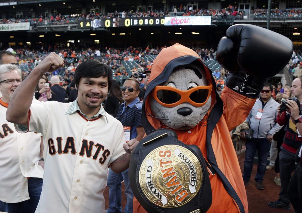 Boxer Manny Pacquiao, left, poses for pictures with San Francisco Giants mascot Lou Seal before Pacquiao was to throw the ceremonial first pitch before a baseball game between the Giants and Milwaukee Brewers on Friday, Aug. 29, 2014, in San Francisco. (AP Photo/Marcio Jose Sanchez)