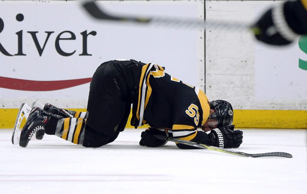 The Boston Bruins' Noel Acciari lies on the ice after being checked by the St. Louis Blues' Tyler Bozak during the third period in Game 5 of the NHL Stanley Cup Final, Thursday, June 6, 2019, in Boston. (AP Photo/Michael Dwyer)