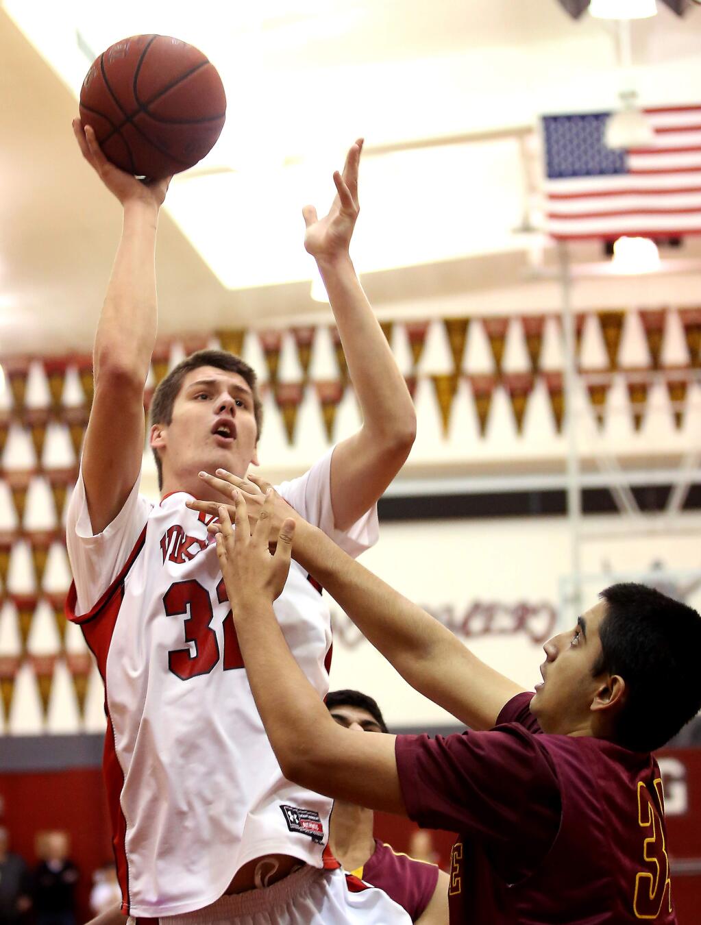 Montgomery's Eric Poulsen is fouled as he goes up for a shot against Northgate's Daniel Gee defends during the game held at Montgomery High School, Friday, February 27, 2015. (Crista Jeremiason / The Press Democrat)