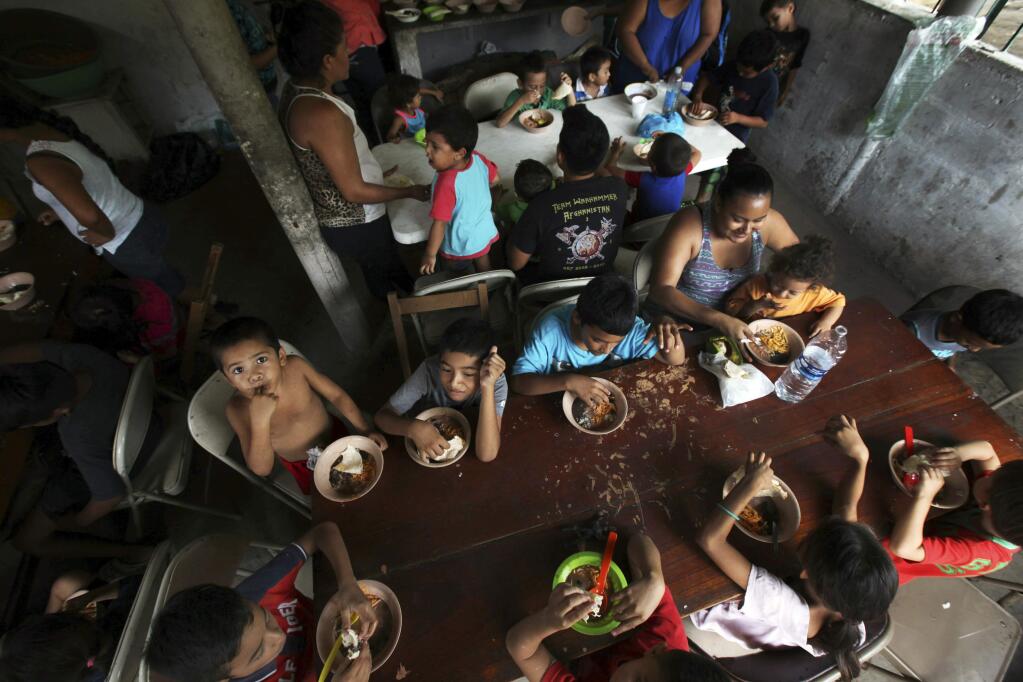 FILE - In this May 30, 2019 file photo, Honduran migrant children eat a meal at the Jesus el Buen Pastor del Pobre y el Migrante shelter in Tapachula, Chiapas state, Mexico. The federal government will be opening a facility at an Army base in Oklahoma to house migrant children and is considering a customs port in southern New Mexico as another option as existing shelters are overwhelmed. The Office of Refugee Resettlement said Tuesday, June 11, 2019 it's dealing with a dramatic spike in the number of children crossing the border without parents. (AP Photo/Marco Ugarte, File)