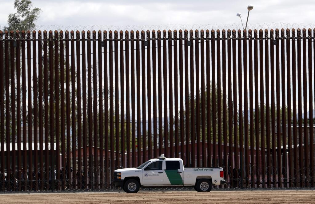 FILE - In this April 5, 2019, file photo, a U.S. Customs and Border Protection vehicle sits near the wall as President Donald Trump visits a new section of the border wall with Mexico in El Centro, Calif. (AP Photo/Jacquelyn Martin, File)