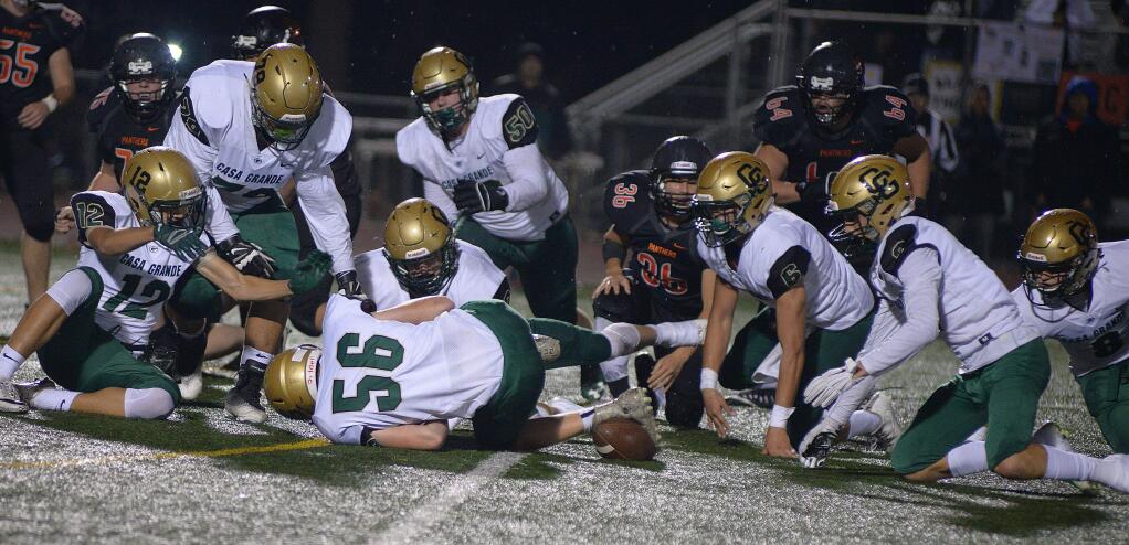 SUMNER FOWLER/FOR THE ARGUS-COURIEREight Casa Grande players surround a Santa Rosa fumble in a North Bay League game won by Casa, 38-36.