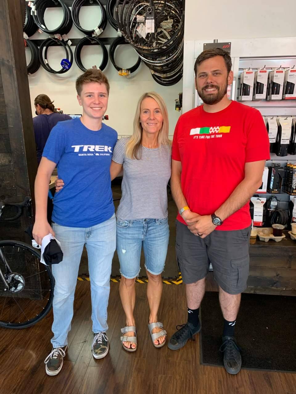 Marisa Denison, center, poses Saturday between Brianna Peebles, left, and Matt Roark of the Trek Bicycle store in Santa Rosa. Denison earlier finished the Ironman 70.3 Santa Rosa with the help of a bike gifted to her by the Trek store after a thief stole the bicycle she intended to ride. (Courtesy of Marisa Denison)