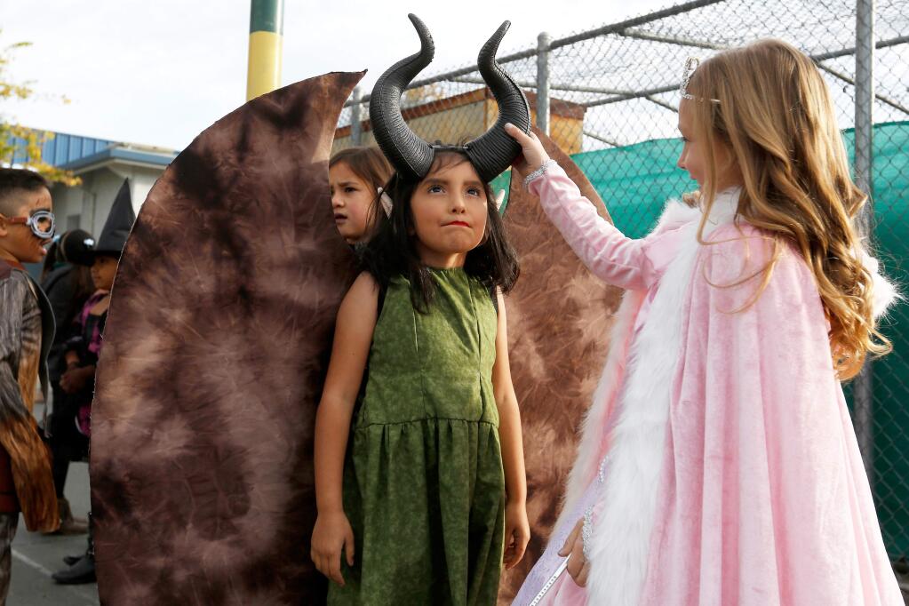 First grader Addison Patane, right, checks out the horns on her classmate Gretel Perez Ayala's costume, at Cali Calmecac Language Academy in Windsor, California, on Wednesday, October 31, 2018. (Alvin Jornada / The Press Democrat)
