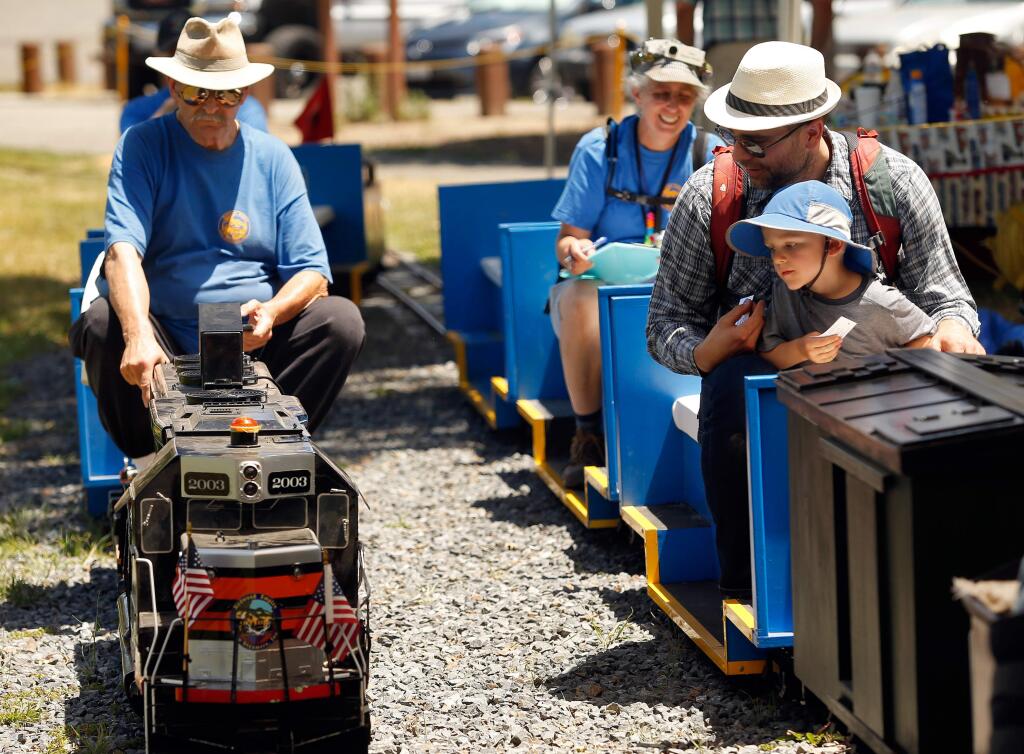 Benji Wright, 3, and his father Matt watch as Gene Chamberlin parks the diesel train beside them, during train rides provided by the Redwood Empire Live Steamers at Youth Community Park in Santa Rosa, California, on Saturday, July 7, 2018. (Alvin Jornada / The Press Democrat)
