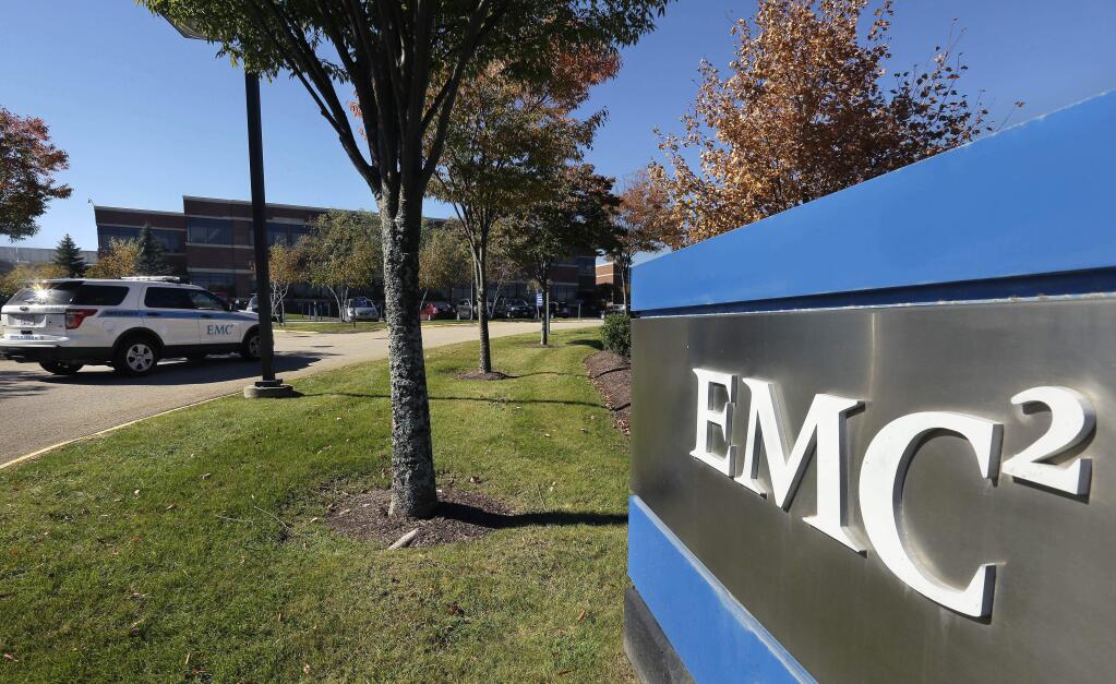 A sign with an EMC logo stands on the company's corporate campus, Monday, Oct. 12, 2015, in Hopkinton, Mass. Dell is buying data storage company EMC in a deal valued at approximately $67 billion. (AP Photo/Steven Senne)