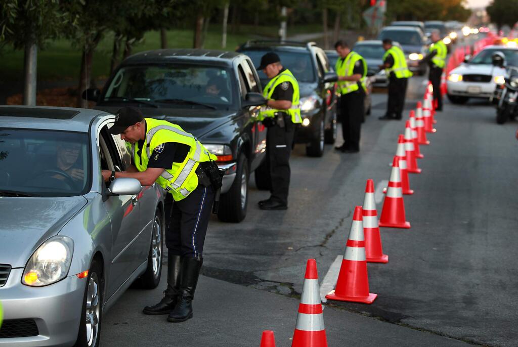 8/1/2010: A1: HIGH-PROFILE CRACKDOWN: Petaluma police officers stop drivers during a recent DUI/driver 's license checkpoint held on Old Redwood Highway.PC: Petaluma police officers stop drivers during a DUI / Drivers License checkpoint held on Old Redwood Highway at North McDowell Extension, Friday, July 23, 2010.