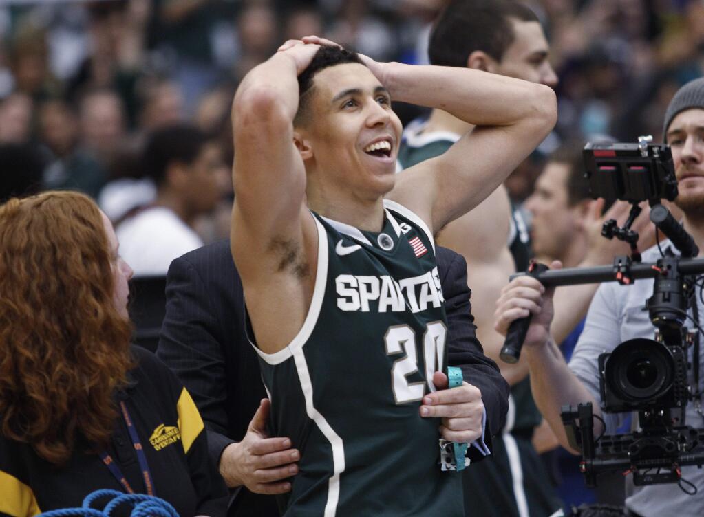 Michigan State's Travis Trice looks up after the regional final against Louisville in the NCAA men's college basketball tournament Sunday, March 29, 2015, in Syracuse, N.Y. Michigan State won 76-70. (AP Photo/Nick Lisi)