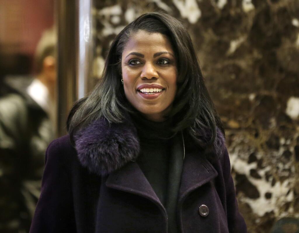 FILE - In this Dec. 13, 2016 file photo, Omarosa Manigault smiles at reporters as she walks through the lobby of Trump Tower in New York. (AP Photo/Seth Wenig)