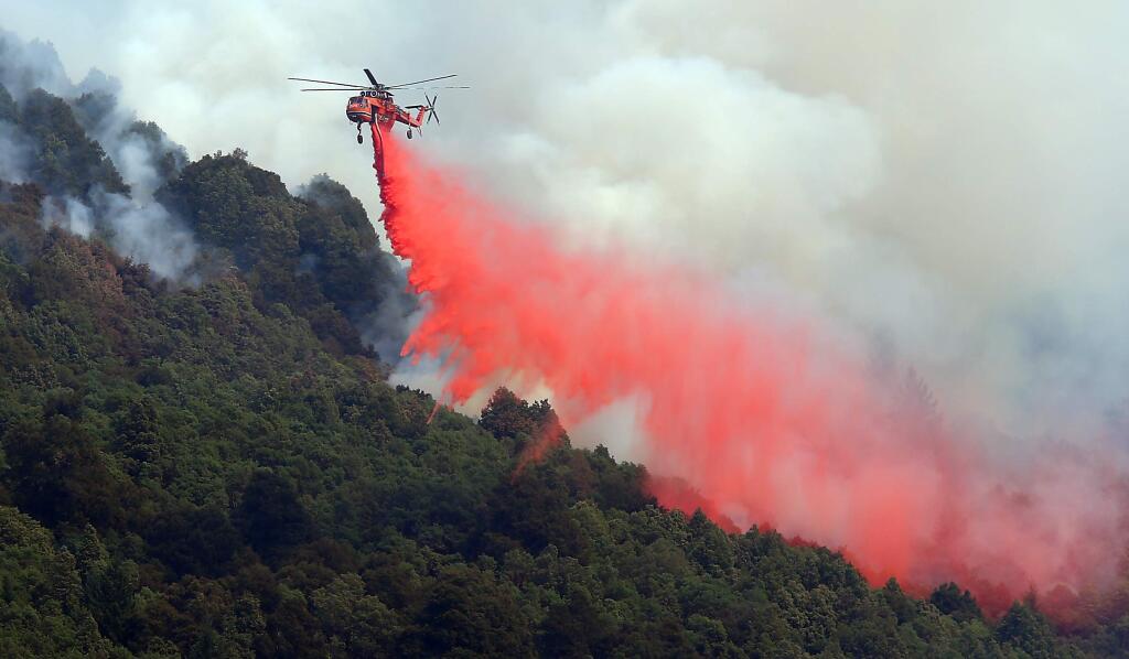 A helicopter drops retardant on an area on the northern end of the Lodge Complex Fire, near Leggett on Monday, Aug. 11, 2014. (Christopher Chung / The Press Democrat)
