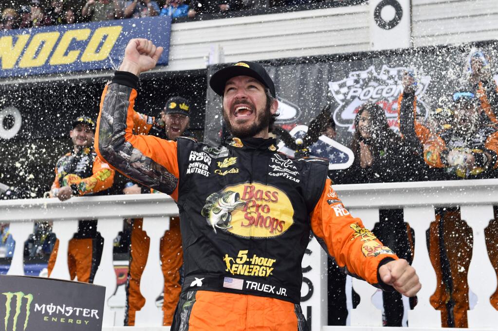 FILE - In this June 3, 2018, file photo, Martin Truex Jr. celebrates in Victory Lane after winning the NASCAR Cup Series auto race in Long Pond, Pa. Truex hopes to continue the good times this weekend at Sonoma Raceway as he tries to pull closer to Kyle Busch and Kevin Harvick in the points standings. Truex won at Sonoma in 2013. (AP Photo/Derik Hamilton, File)