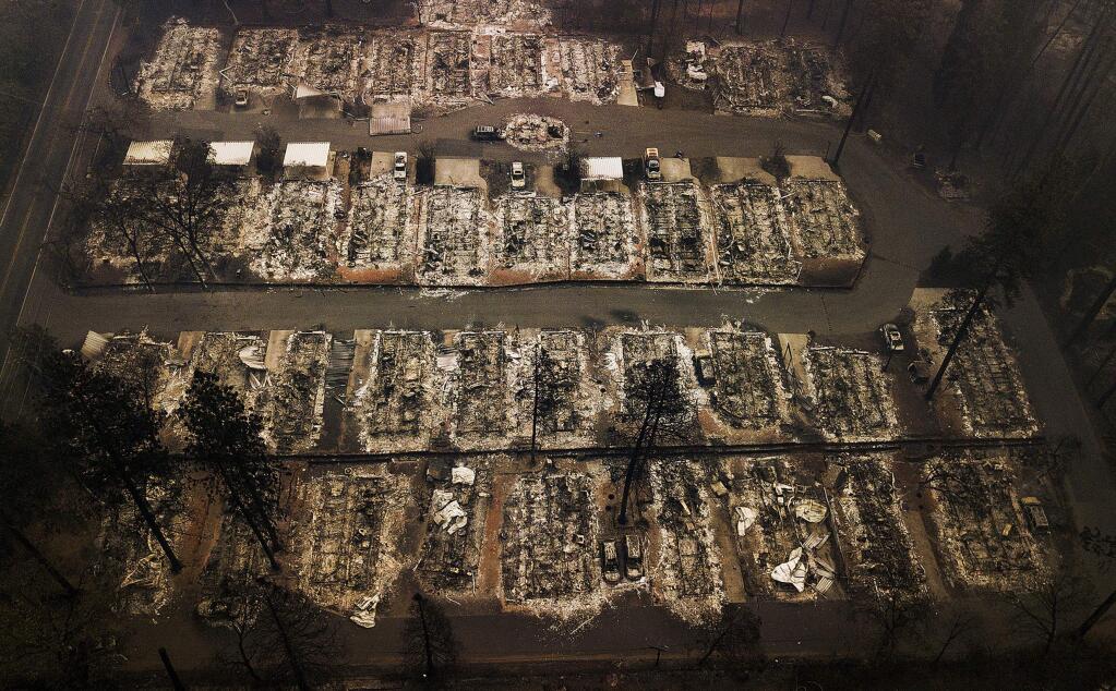 FILE - This Nov. 15, 2018, aerial file photo, shows the remains of residences leveled by the Camp Fire in Paradise, Calif. A federal bankruptcy court judge on Wednesday, Nov. 27, 2019, rejected Pacific Gas & Electric's latest attempt to change a California law requiring utilities to pay for the devastation from wildfires ignited by their electrical equipment. The decision issued by U.S. Bankruptcy Judge Dennis Montali preserves a long-standing principle known as 'inverse condemnation.' (AP Photo/Noah Berger, File)