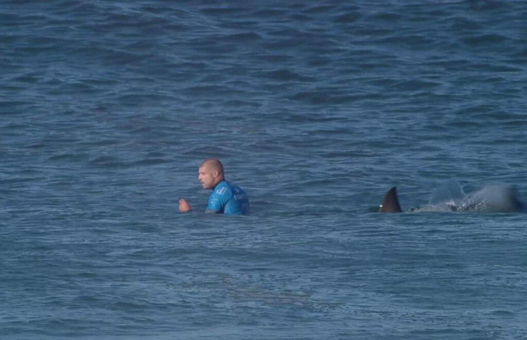 In this screen shot taken from video made available by the World Surf League, Australian surfer Mick Flanning is pursued by a shark, in Jeffrey's Bay, South Africa, Sunday, July 19, 2015. (World Surf League via AP) MANDATORY CREDIT FOR ALL ONLINE USE PLEASE INCLUDE A LINK TO WORLDSURFLEAGUE.COM.