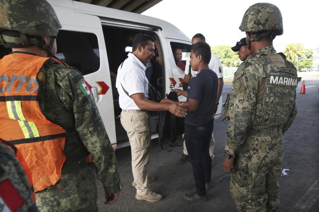 A migrant is detained by Mexican immigration officials at a checkpoint where soldiers are stationed on the highway in Tapachula, Chiapas state, Mexico, June 10, 2019. Mexican and U.S. officials reached an accord late Friday that calls on Mexico to crackdown on migrants in exchange for Trump backing off his threat to impose a 5% tariff on Mexico‚Äôs exports. (AP Photo/Marco Ugarte)