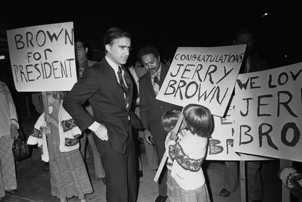 FILE - In this May 20, 1976, file photo, California Gov. Edmund G. Brown Jr. is greeted by backers and sign-carrying youngsters upon his return to Sacramento, Calif., following his victory in the Maryland Democratic presidential primary election. Brown made three unsuccessful attempts for the White House. Brown leaves office Jan. 7, 2019, after a record four terms in office, from 1975-1983 and again since 2011. (AP Photo/Walter Zeboski, File)