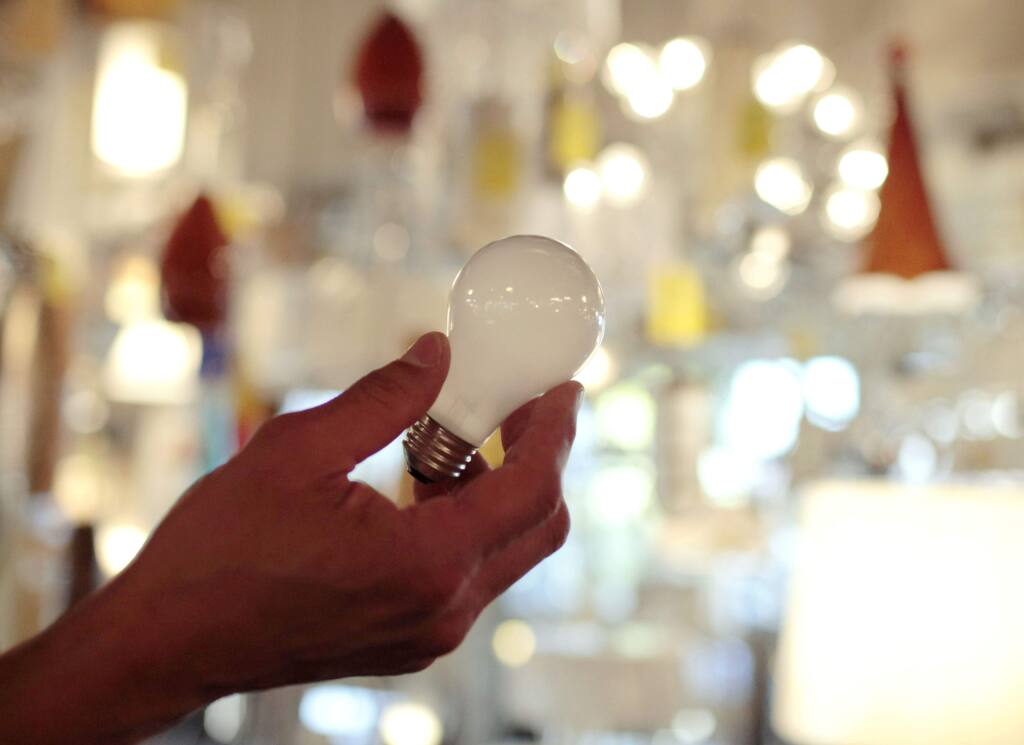 FILE - In this Jan. 21, 2011, file photo, Manager Nick Reynoza holds a 100-watt incandescent light bulb at Royal Lighting in Los Angeles. (AP Photo/Jae C. Hong, File)