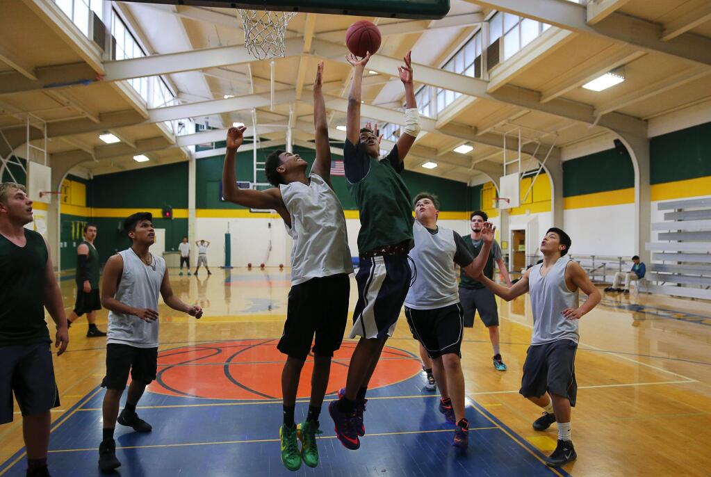Archbishop Hanna's Yuera Blaylock , green jersey, takes a shot over Josh Manzano during practice, in Sonoma, on Tuesday, March 8, 2016. (Christopher Chung/ The Press Democrat)