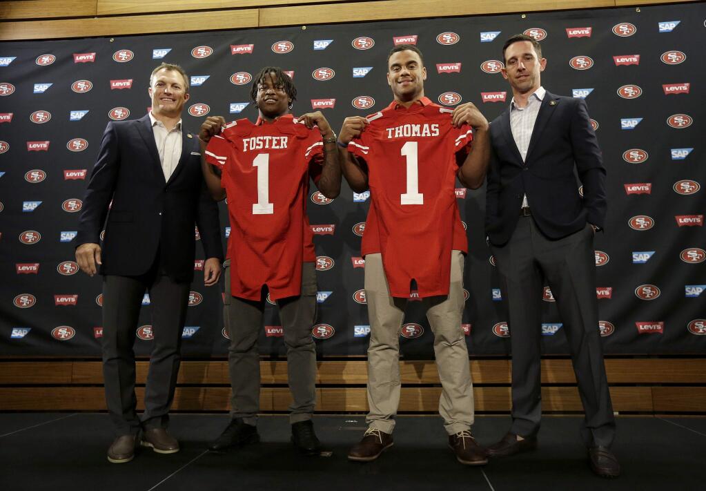 From left to right, San Francisco 49ers general manager John Lynch poses for photos with draft picks Reuben Foster, Solomon Thomas and head coach Kyle Shanahan at a news conference in Santa Clara, Friday, April 28, 2017. (AP Photo/Jeff Chiu)