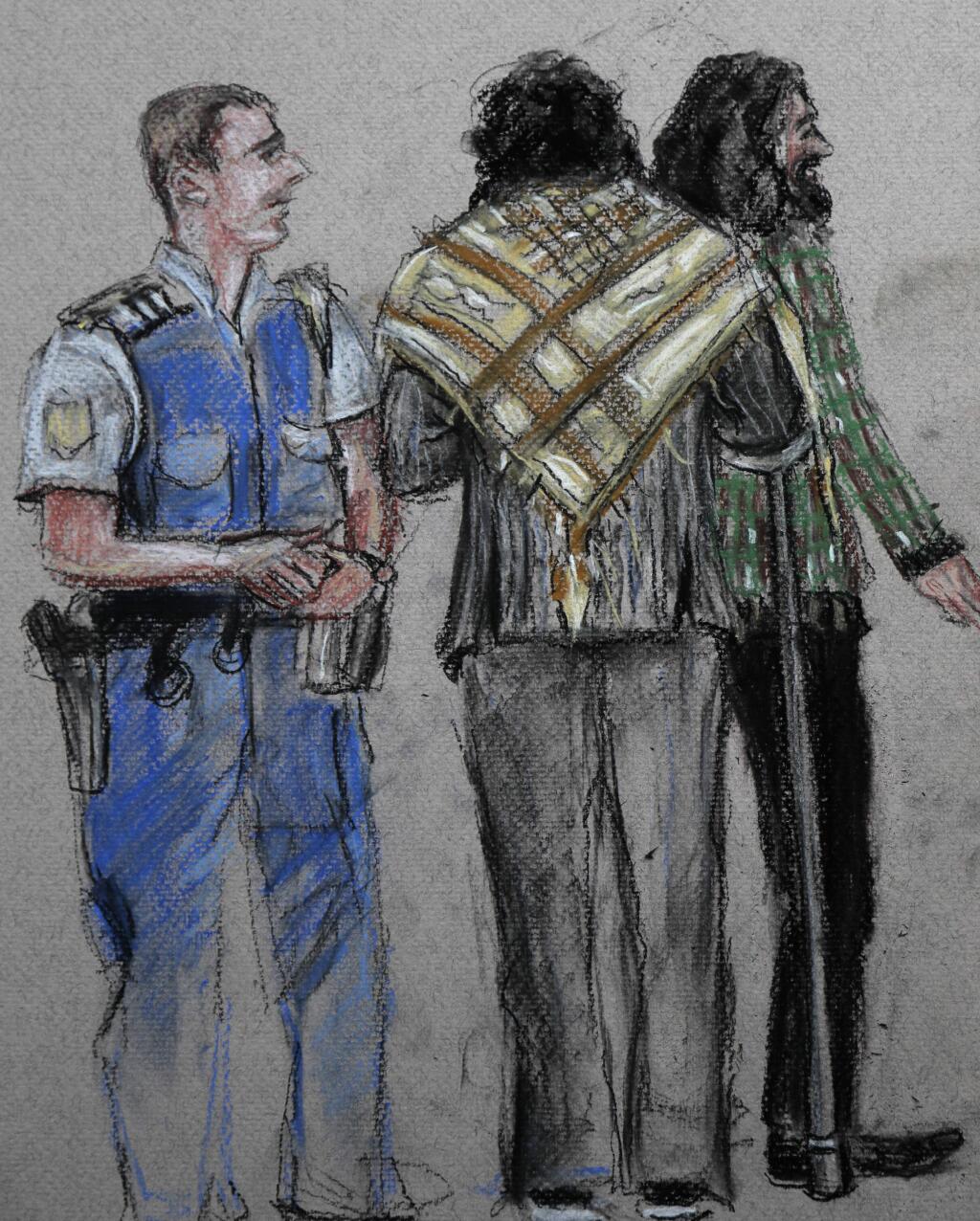 In this courtroom drawing, a police officer stands by victims as Brenton Tarrant, the man accused of killing 51 people at two Christchurch mosques on March 15, 2019, appears via video link at the Christchurch District Court, from the maximum security prison in Auckland where he's being held, New Zealand, Friday, June 14, 2019. Tarrant pleaded not guilty to all the charges filed against him. (AP Photo/Stephanie McEwin)