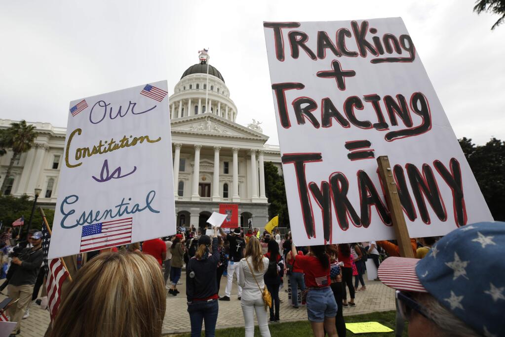 Protesters calling for California Gov. Gavin Newsom to end his stay-at-home orders rally outside the Capitol in Sacramento, Calif., Monday, April 20, 2020. Several hundred people gathered demanding that Newsom ease the restrictions and allow people return to work. (AP Photo/Rich Pedroncelli)