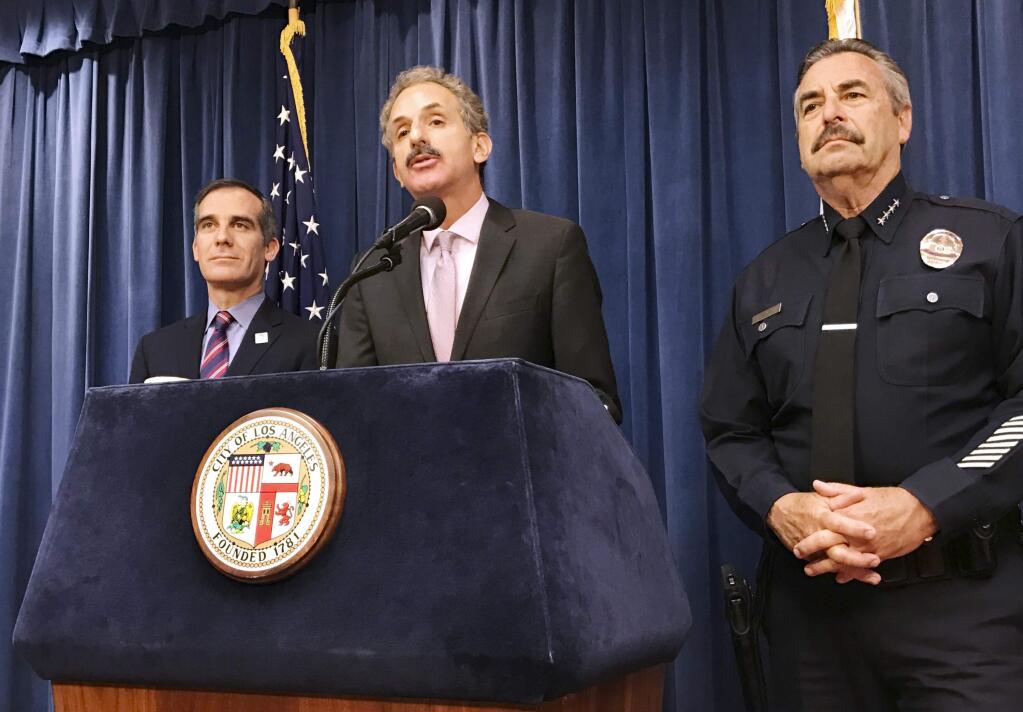 Los Angeles City Attorney Mike Feuer, middle, is flanked by Police Chief Charlie Beck, right, and Mayor Eric Garcetti during a press conference in Los Angeles Thursday, April 12, 2018. A federal judge in Los Angeles has issued a nationwide injunction barring the Justice Department from awarding priority consideration for a community policing grant if they agreed to cooperate with immigration officials. Feuer said the ruling was a 'complete victory.' (AP Photo/Mike Balsamo)