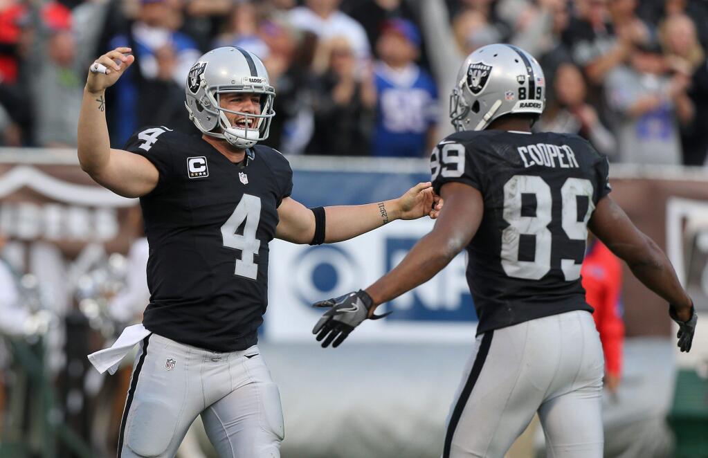 Oakland Raiders quarterback Derek Carr, left, and wide receiver Amari Cooper celebrate connecting for a touchdown in the fourth quarter against the Buffalo Bills in Oakland on Sunday, Dec. 4, 2016. The Raiders defeated the Panthers 38-24. (Christopher Chung / The Press Democrat)