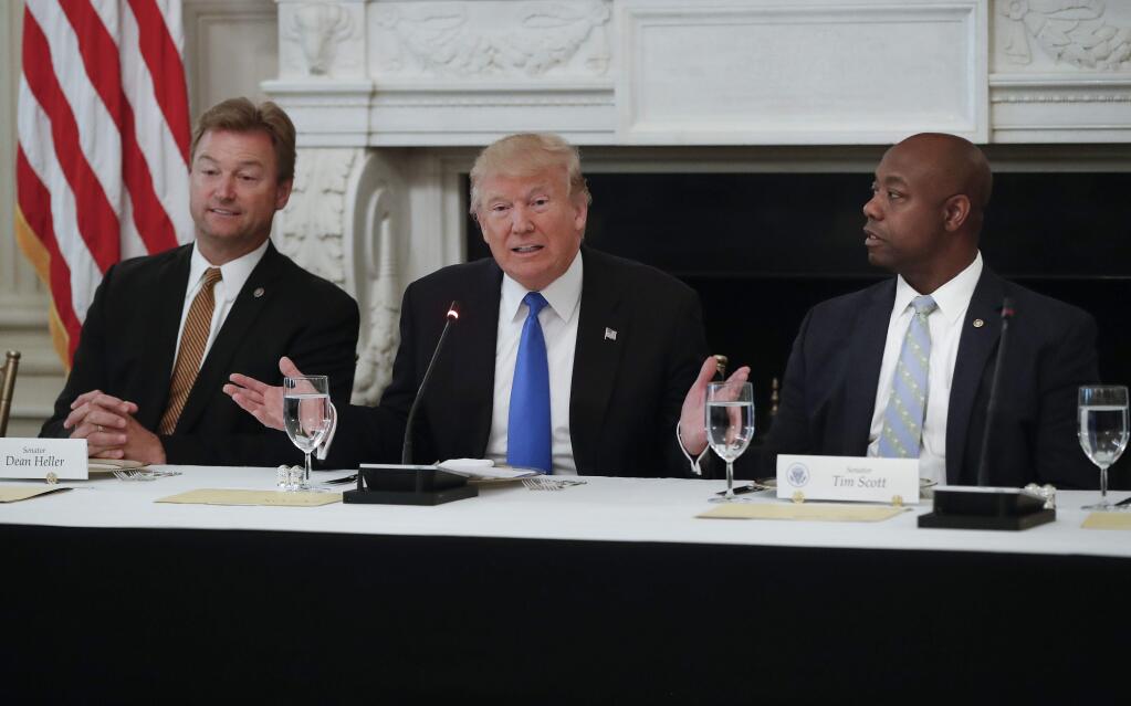 President Donald Trump, flanked by Sen. Dean Heller, R-Nev., left, and Sen. Tim Scott, R-S.C.,speaks at a luncheon with GOP leadership, Wednesday, July 19, 2017, in the State Dinning Room of the White House in Washington. (AP Photo/Pablo Martinez Monsivais)