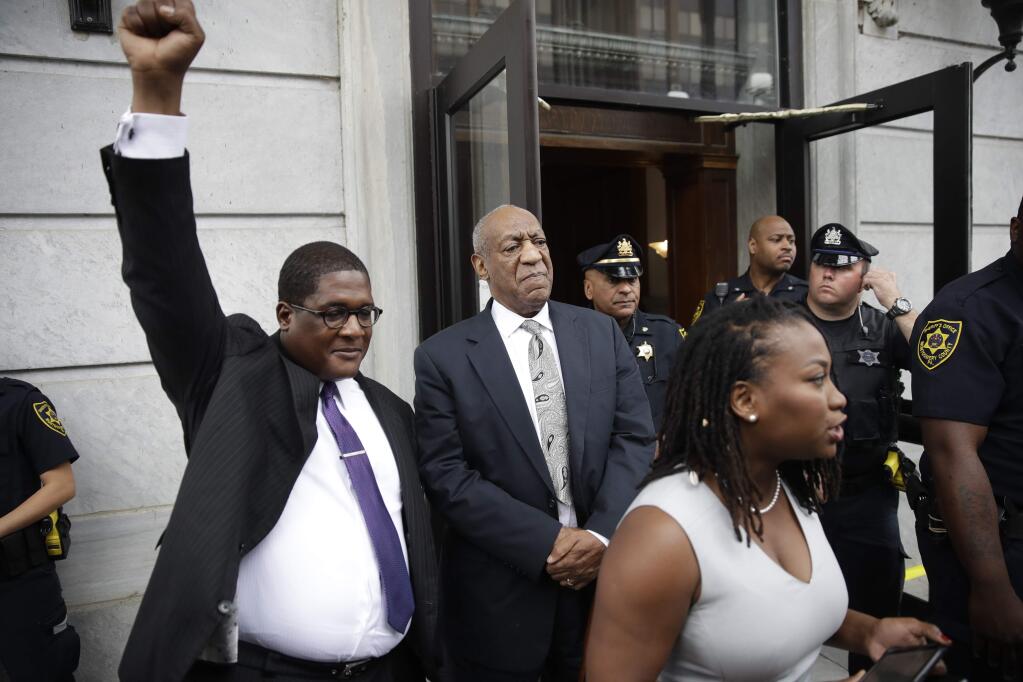 Andrew Wyatt raises his fist as Bill Cosby exits the Montgomery County Courthouse after a mistrial was declared in Norristown, Pa., Saturday, June 17, 2017. Cosby's trial ended without a verdict after jurors failed to reach a unanimous decision. (AP Photo/Matt Rourke)