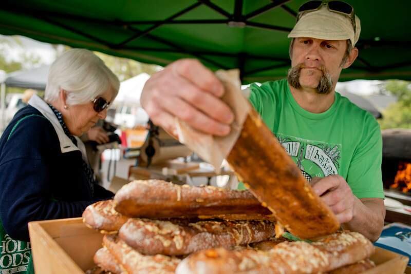 Mike 'the bejkr' Zakowski bags a stecca baguette at the Friday Sonoma farmers market. (Alvin Jornada/Press Democrat)